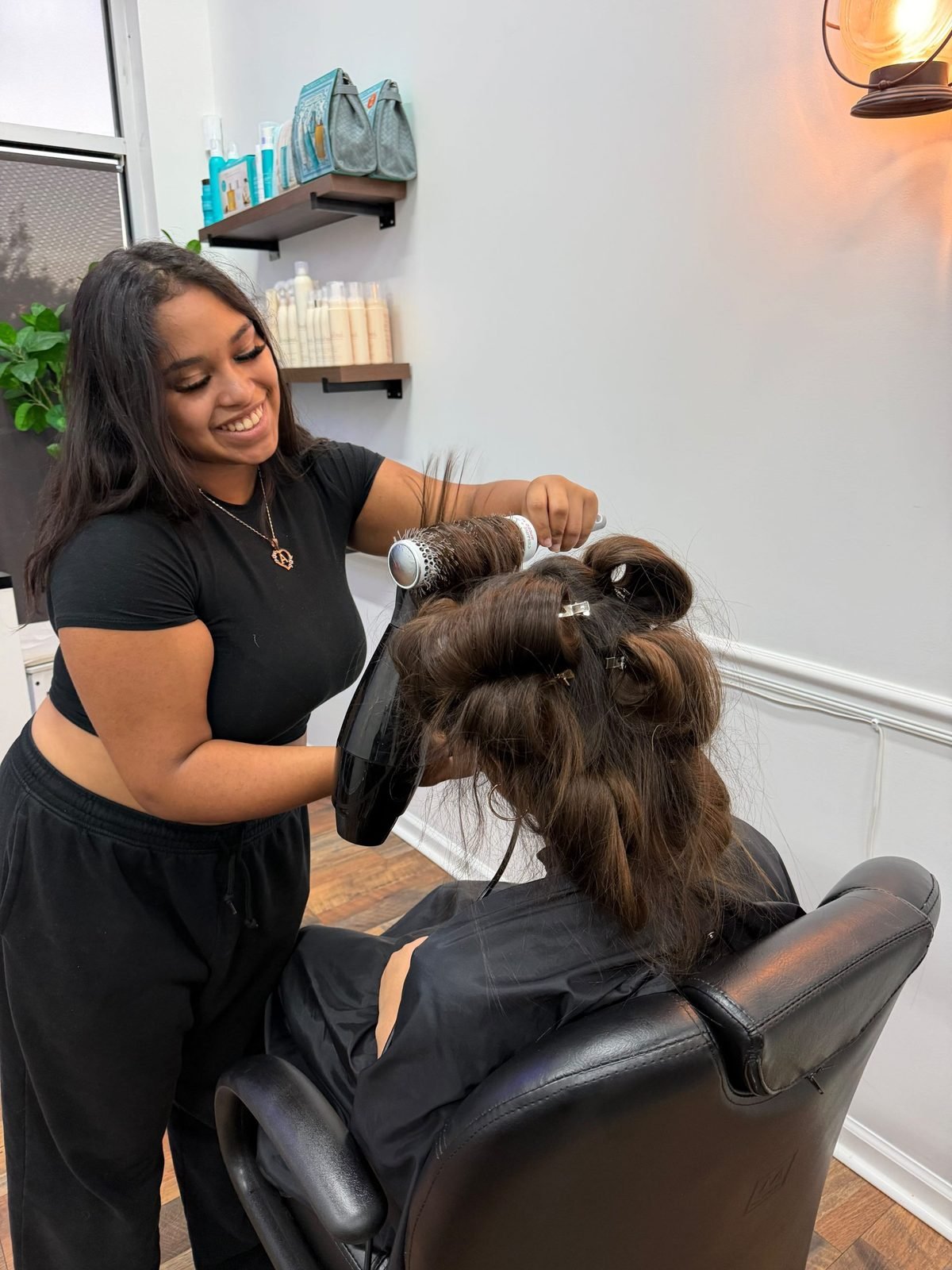 A stylist blow-drying a client's hair at Hair Studio & More
